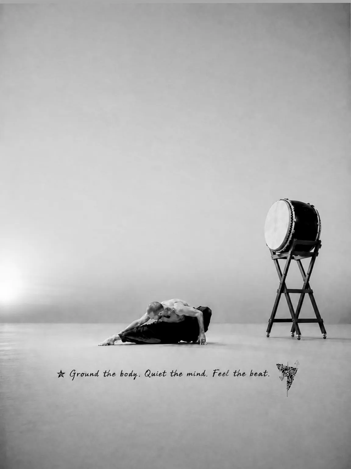 מתופף טאיקו כורע לצד תוף גדול — Ground the body. Quiet the mind. Feel the beat.